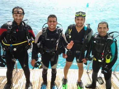 a group of three men in scuba gear on a boat at Funnydivers Diving center in Hurghada