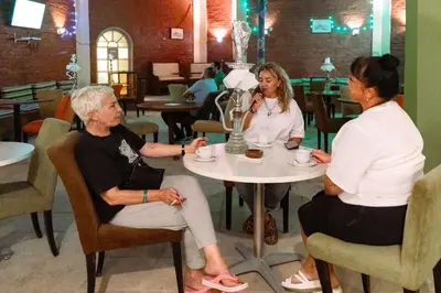 three people sitting around a table in a restaurant at Apartment Empire Hotel in Hurghada