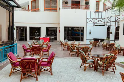 a group of tables and chairs in a patio at Apartment Empire Hotel in Hurghada