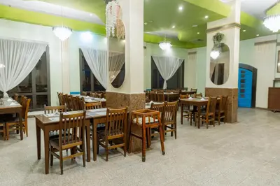 a dining room with wooden tables and chairs at Apartment Empire Hotel in Hurghada