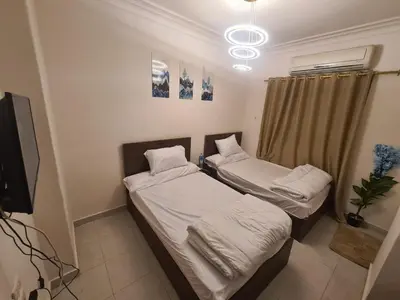 two beds in a small room with a tv at Chalet for rent near the sea Services and tourist walkway in Hurghada