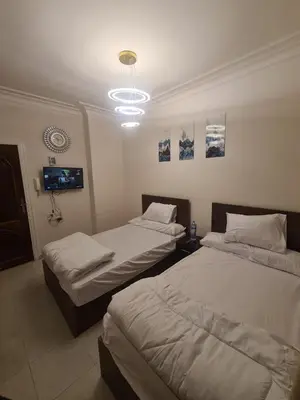a room with two beds and a tv in it at Chalet for rent near the sea Services and tourist walkway in Hurghada