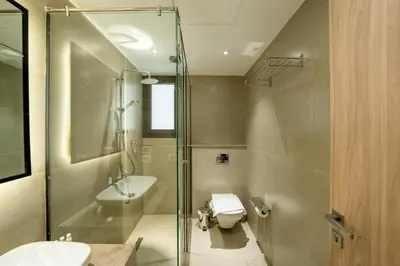 a bathroom with a shower and a toilet and a sink at Elegant Fanadir Marina 2BR • Ground Floor in Hurghada