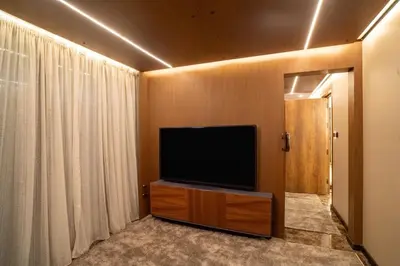 a living room with a flat screen tv on a wooden wall at Supperyacht Jack Sparrow in Hurghada