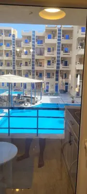 a swimming pool in front of a large building at Gamela in Hurghada
