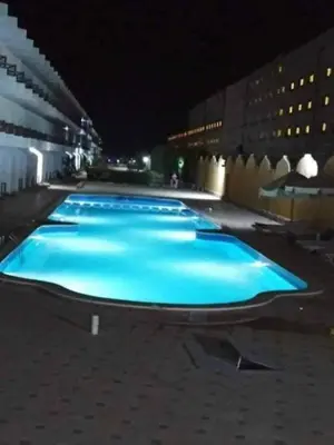 a row of blue pools in a building at night at كومباوند فوكس هاوس in Hurghada