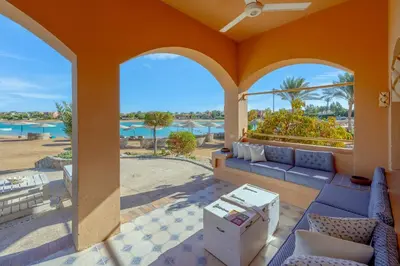 a porch with a couch and a view of the ocean at Rihanna apartment direct to the sea in Hurghada