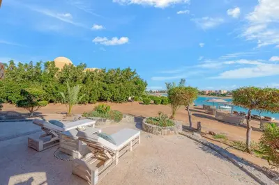 a patio with two lounge chairs and a body of water at Rihanna apartment direct to the sea in Hurghada