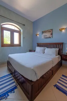 a large bed in a bedroom with a window at Rihanna apartment direct to the sea in Hurghada