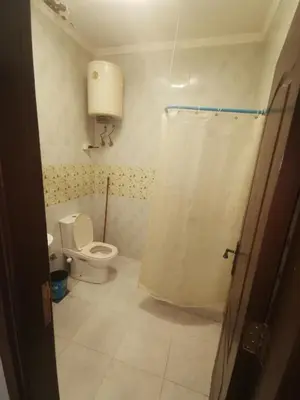 a bathroom with a toilet and a shower curtain at Lotus Stay شاليه مفروش بالغردقة in Hurghada