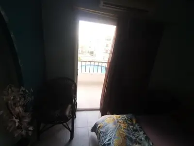a bedroom with a window and a bed and a chair at Lotus Stay شاليه مفروش بالغردقة in Hurghada