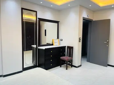 a bathroom with a vanity and a large mirror at Comfortable & Modern Appartement in Luxor