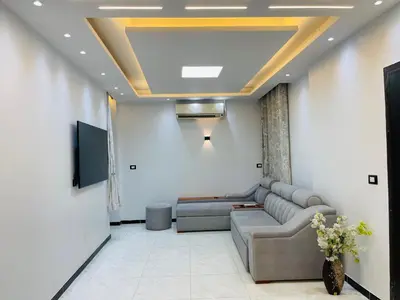 a living room with a couch and a tv at Comfortable & Modern Appartement in Luxor
