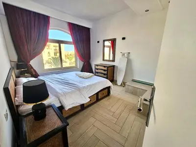 a bedroom with a large bed and a window at Beachfront Apartment Somabay in Hurghada