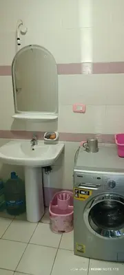 a bathroom with a sink and a washing machine at شقة كورنيش النيل 3غرف فيو كامل علي النيل in Aswan