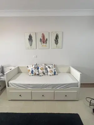 a white bed in a room with four pictures on the wall at Studio sea view in Hurghada