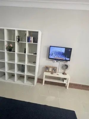 a living room with white shelves and a flat screen tv at Studio sea view in Hurghada