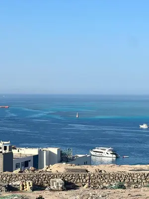 a large boat in the water next to a building at Studio sea view in Hurghada