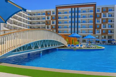 a bridge over a pool in front of a building at Tiba Golden Resort with private Beach in Hurghada
