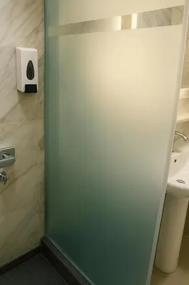 a glass door in a bathroom with a sink at Tiba Golden Resort with private Beach in Hurghada
