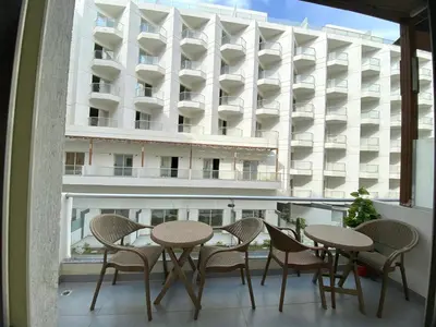 a balcony with tables and chairs and a building at Luxury serviced apartments in Hurghada
