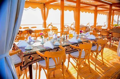 a dining room with a long table and chairs at دهبيه كوين شارلوت in Luxor