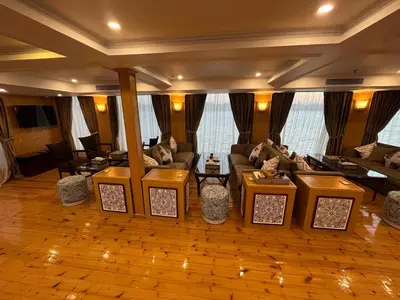 a living room with couches and tables and windows at دهبيه كوين شارلوت in Luxor