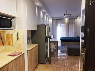 a kitchen with a refrigerator and a room with a bed at Florenza Khamsin, Studio i415-B in Hurghada
