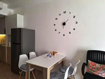 a kitchen with a table and a clock on the wall at Florenza Khamsin, Studio i415-B in Hurghada