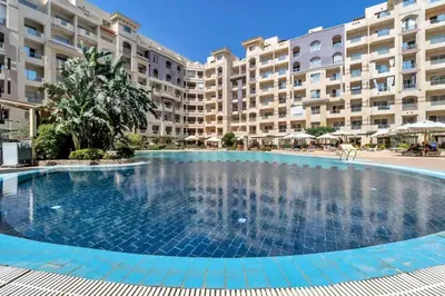 a large swimming pool in front of a large apartment building at Florenza Khamsin, Studio i415-B in Hurghada
