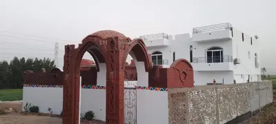 a white house with a gate in front of it at Villa Saeed in Al Karnak