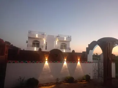 a white building with lights on the side of it at Villa Saeed in Al Karnak