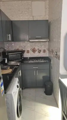 a small kitchen with a stove and a microwave at Villa Saeed in Al Karnak