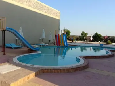 a swimming pool with a slide in a resort at Cecelia Resort - Studio chalet in Hurghada