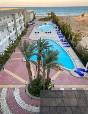 an aerial view of a resort with two pools and palm trees at Cecelia Resort - Studio chalet in Hurghada
