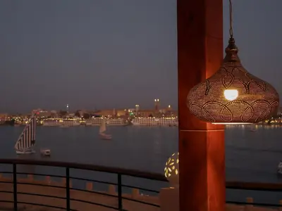 a light hanging from a pole with a view of a river at Boutique hotel Neferu Stay in Luxor