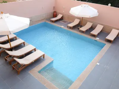 a pool with chairs and umbrellas and a swimming pool at Boutique hotel Neferu Stay in Luxor