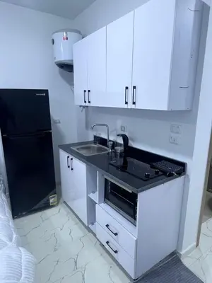 a kitchen with white cabinets and a sink and a refrigerator at الغردقه الشيراتون القديم in Hurghada
