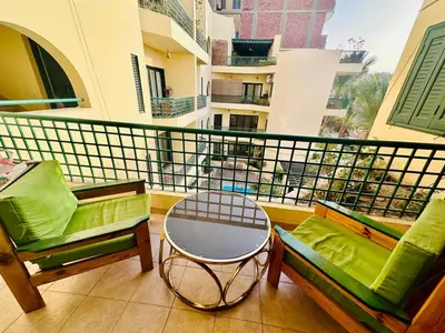 a balcony with two chairs and a table on a balcony at Enjoy a peaceful stay in Hurghada