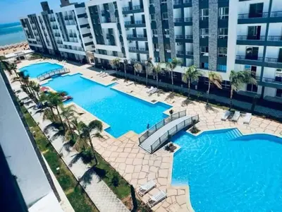 an overhead view of two swimming pools in front of a building at Fanadir Bay Apartments in Hurghada