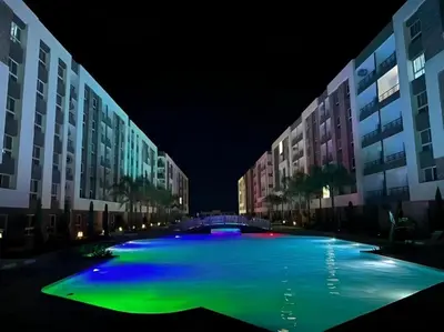 a large swimming pool at night with buildings at Fanadir Bay Apartments in Hurghada