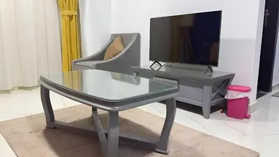 a living room with a glass coffee table and a tv at Fanadir Bay Apartments in Hurghada