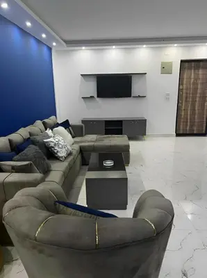 a living room with couches and a flat screen tv at Fanadir Bay Apartments in Hurghada