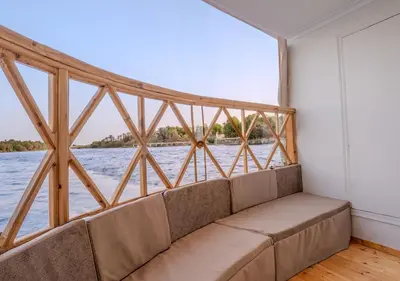a couch in a room with a view of the water at Anoush Dahabiya 4 nights from Luxor to Aswan each Monday in Luxor