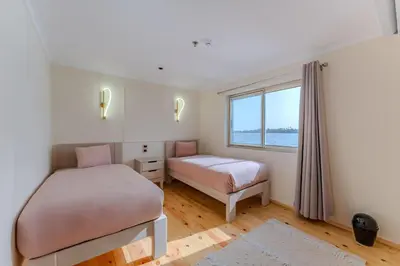 two beds in a room with a window at Anoush Dahabiya 4 nights from Luxor to Aswan each Monday in Luxor