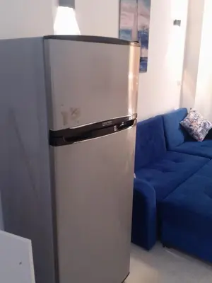 a refrigerator in a living room with a blue couch at Hurghada Apartment sea view Fiesta 209 in Hurghada