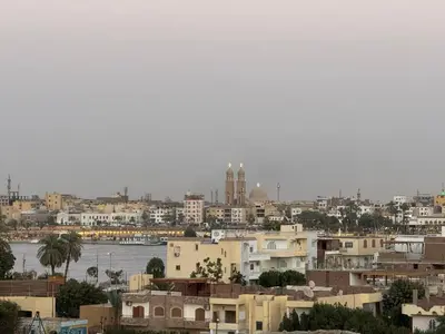 a city with buildings and a body of water at Maat Studio in Luxor