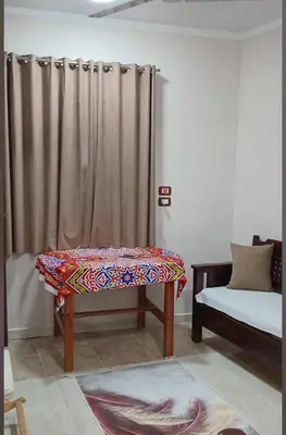 a living room with a bench and a curtain at Maat Studio in Luxor