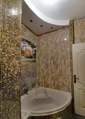 a bathroom with a bath tub and a tile wall at مبارك 5 in Hurghada