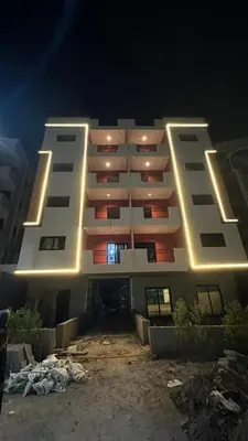 a large white building with lights on it at night at مبارك 5 in Hurghada